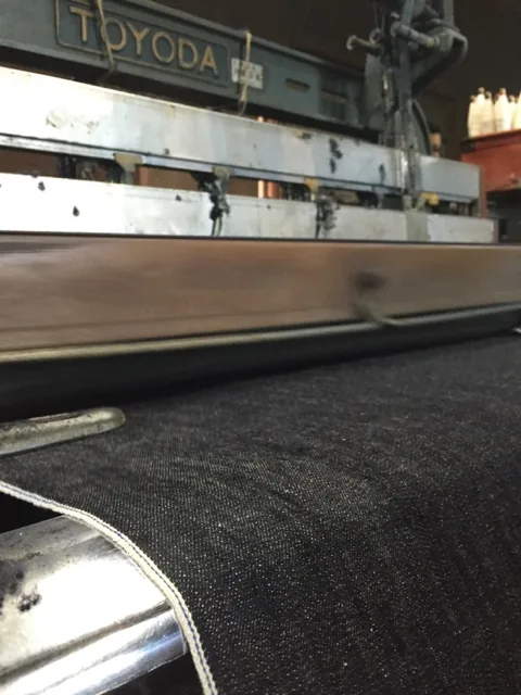 A vintage Toyoda shuttle loom weaves selvedge denim at slow speeds for Pure Blue Japan.