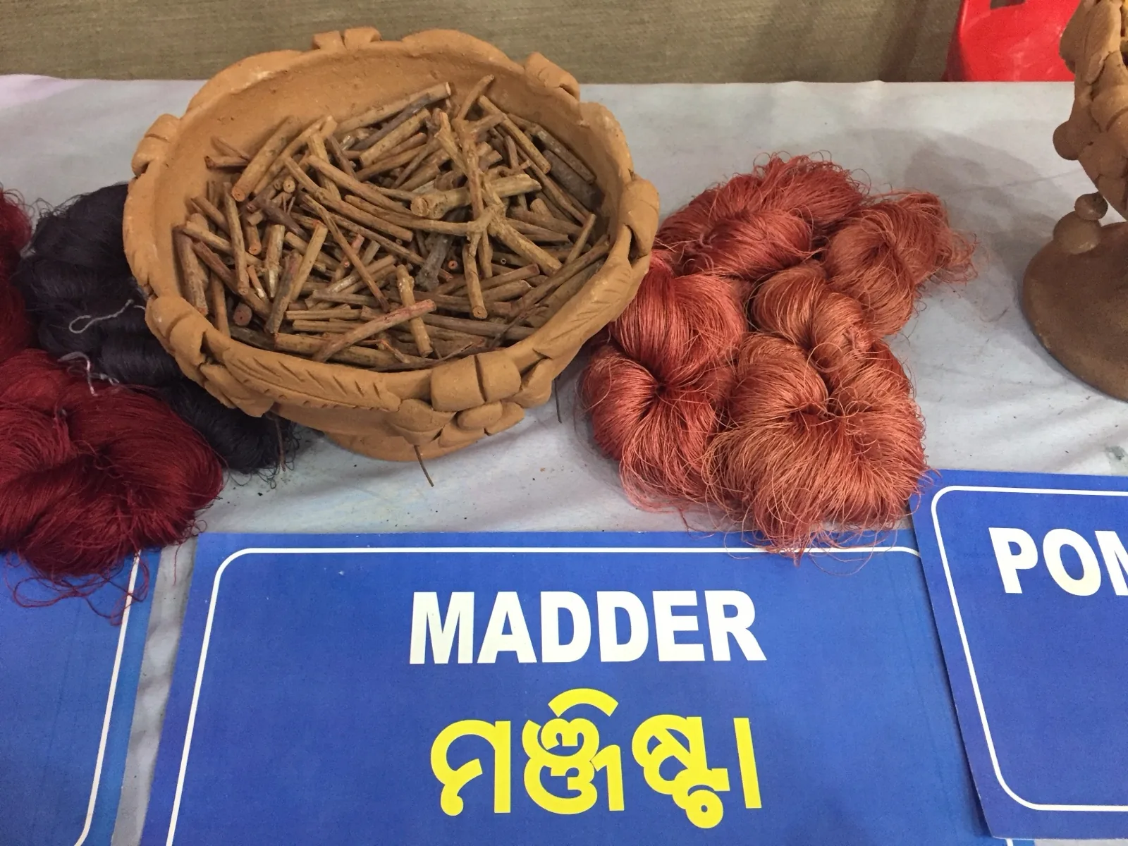 A range of red, pink, and orange yarn samples dyed with madder root under different mordants