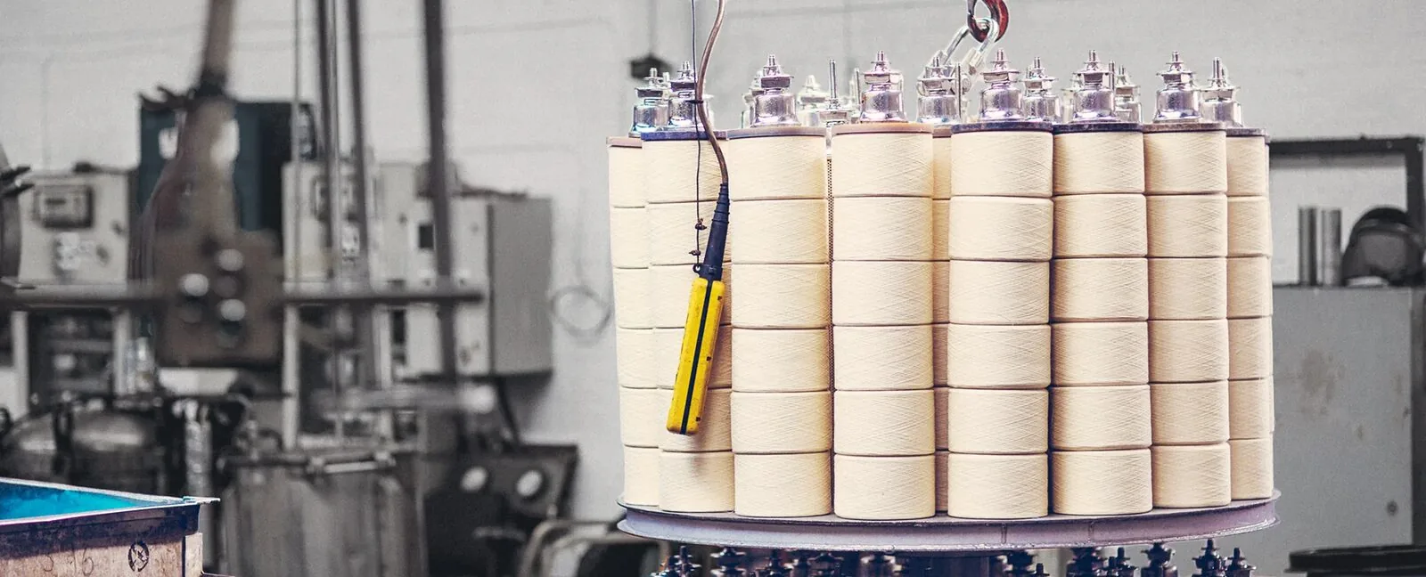 Several cylindrical yarn packages mounted together on a dyeing machine.