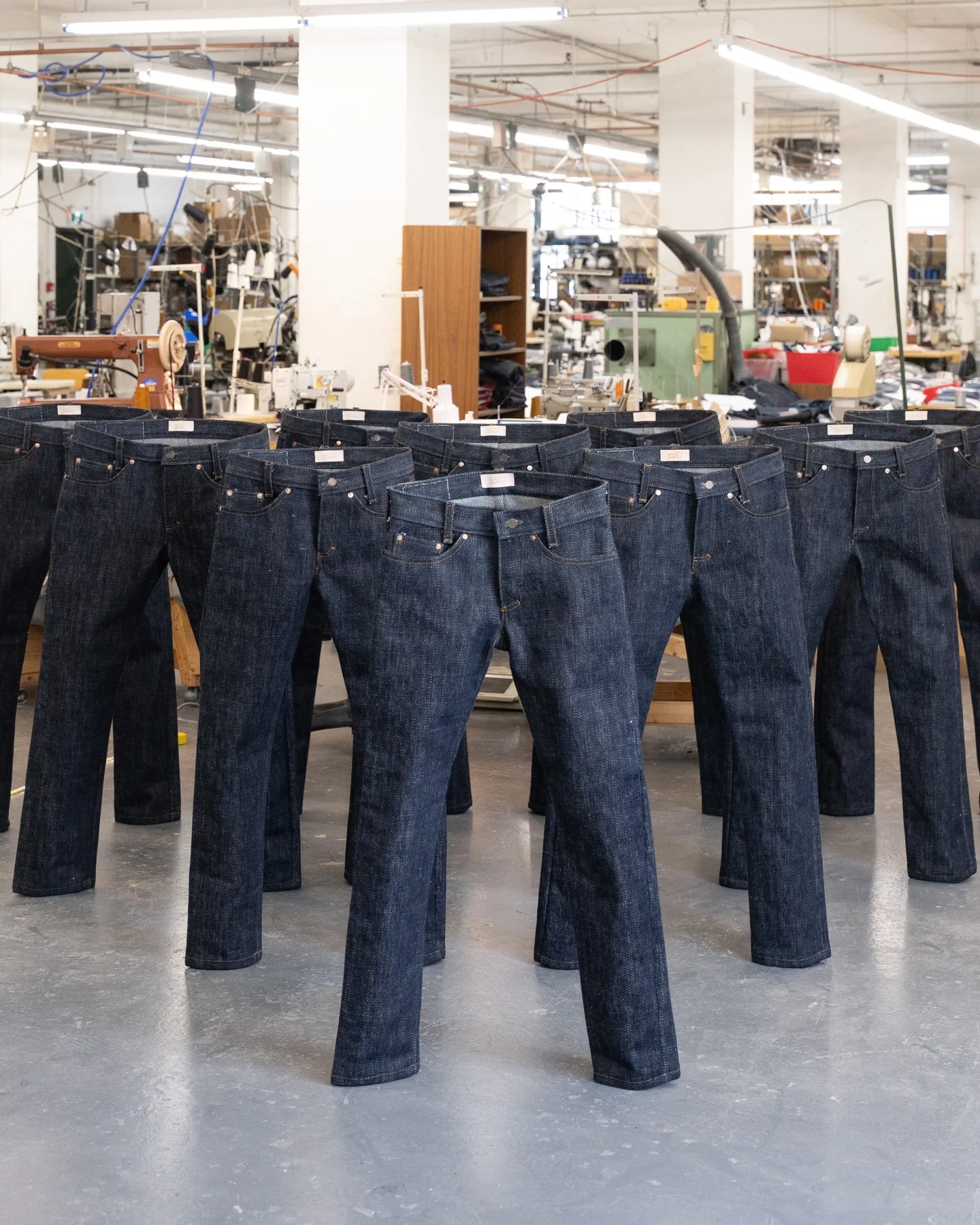 Many pairs of heavyweight raw denim standing on their own.